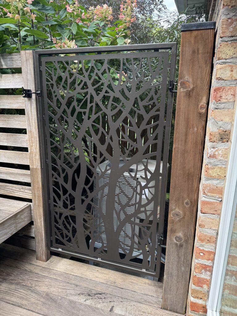 Laser cut privacy screen, tree of life connected to wooden posts and metal latch.