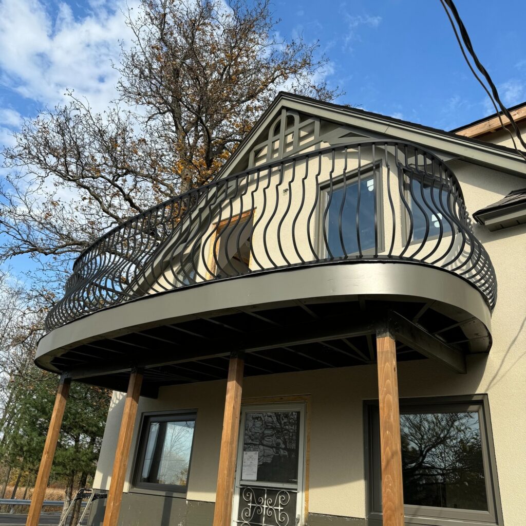 Custom fabricated Juliet balcony railing by Dream Ironwork featuring traditional belly-shaped pickets, handcrafted wrought iron construction, and a classic elegant design for residential exteriors.