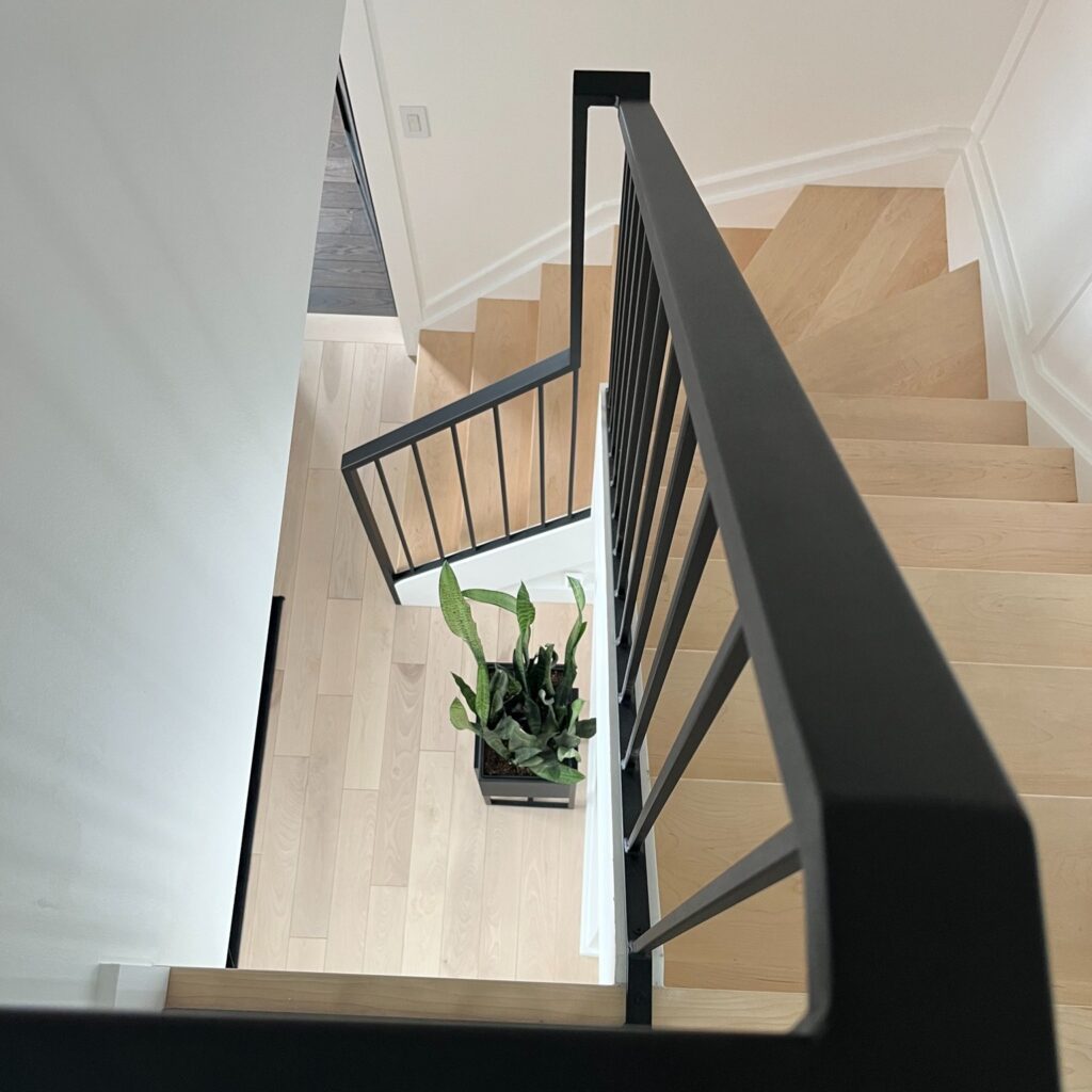 Modern interior metal handrails interior with wooden steps. Interior metal handrail contractor in niagara region. Interior metal railings.