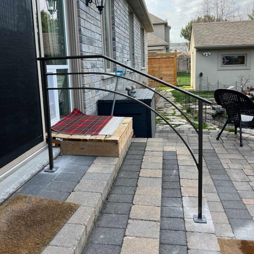 Custom fabricated front porch iron railing with a double half-arch feature and open-concept design by Dream Ironwork, showcasing precision craftsmanship, durable welded construction, and elegant modern curb appeal.
