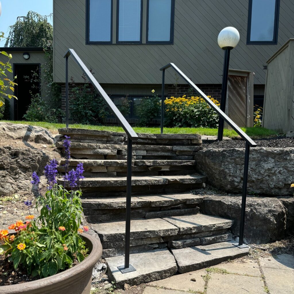 Custom fabricated outdoor iron garden railing installed on natural stone stairs by Dream Ironwork, featuring durable welded construction, clean modern lines, and long-lasting craftsmanship for residential exterior railings.