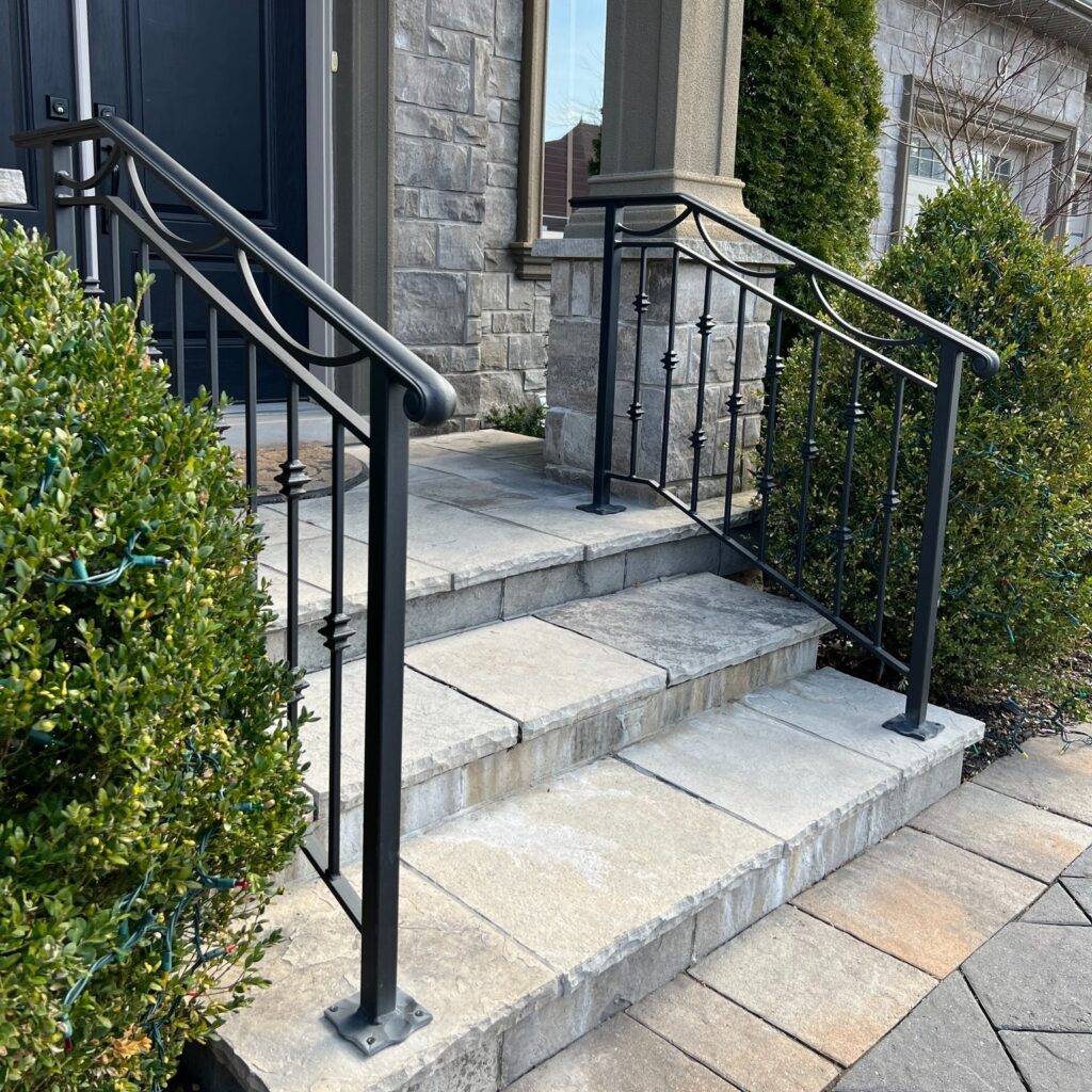 Custom fabricated wrought iron railing by Dream Ironwork featuring a 4-inch window with a half-moon design and alternating single and double Prince knuckle pickets, handcrafted for strength and decorative appeal.