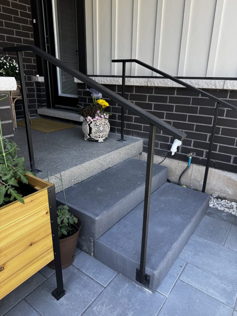 Side mount railing installed on a concrete front porch.
