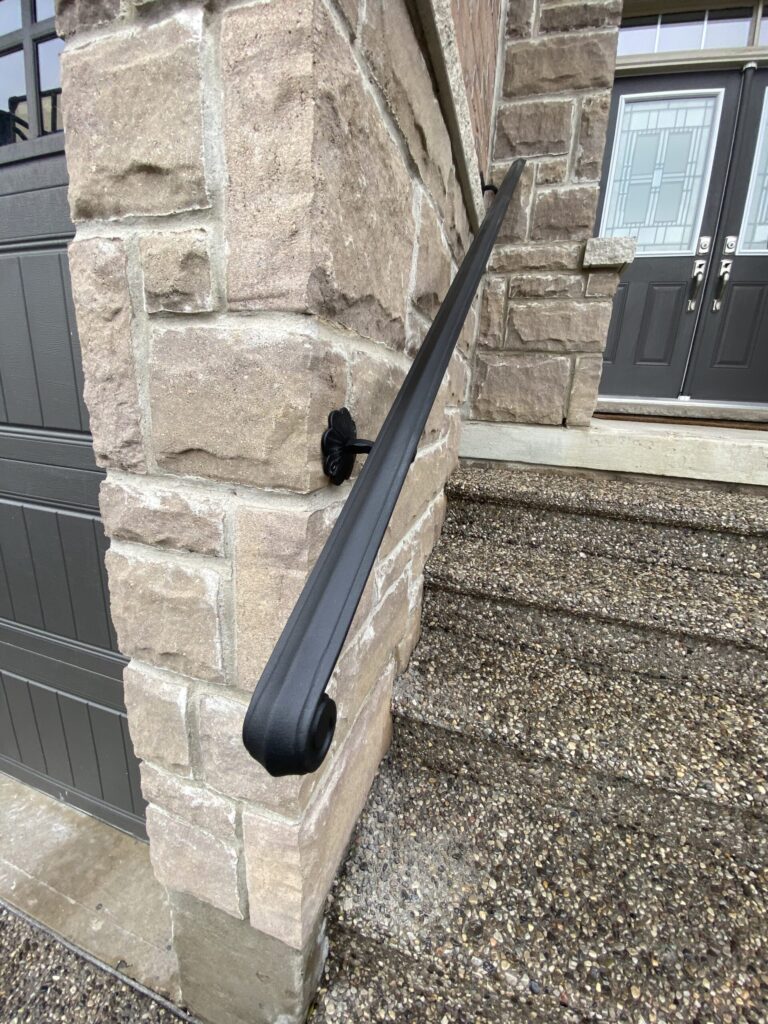 Wrought iron railing professionally installed on stone exterior wall