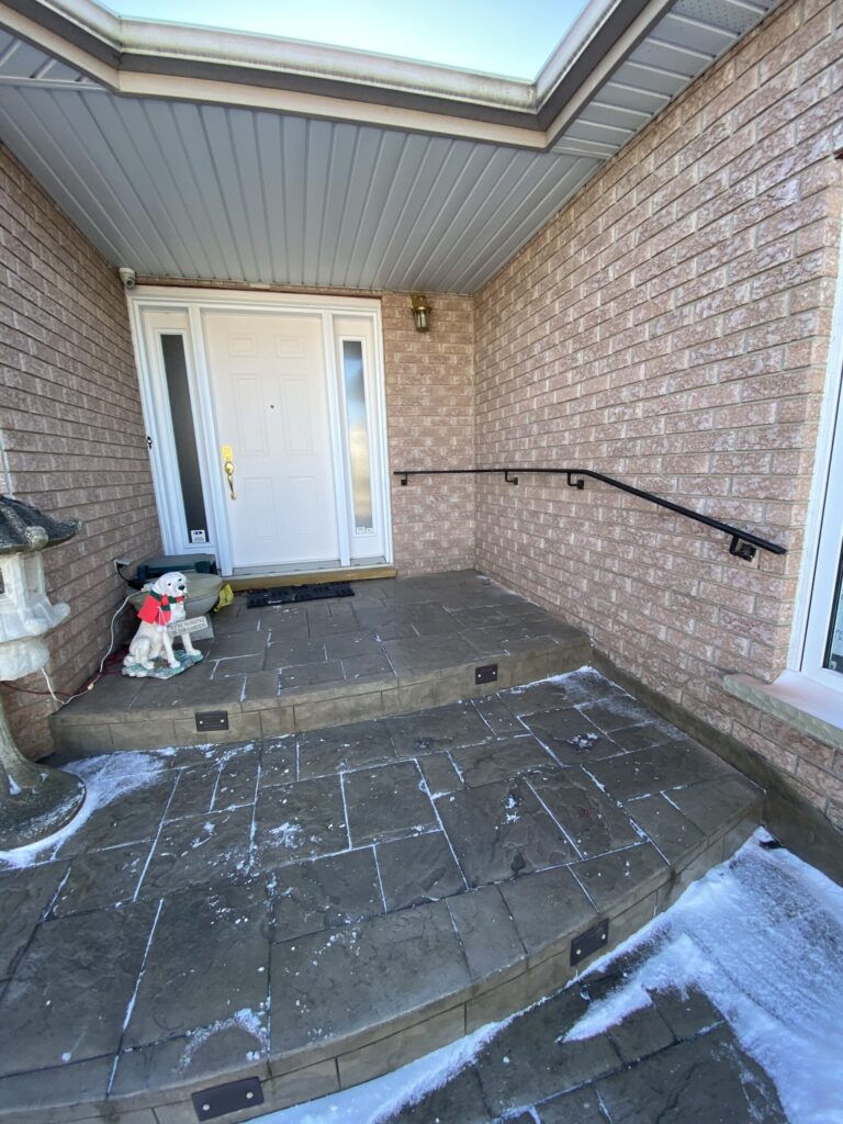 Wrought iron railing professionally installed on brick exterior wall