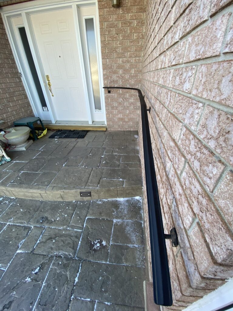 Wrought iron railing professionally installed on brick exterior wall