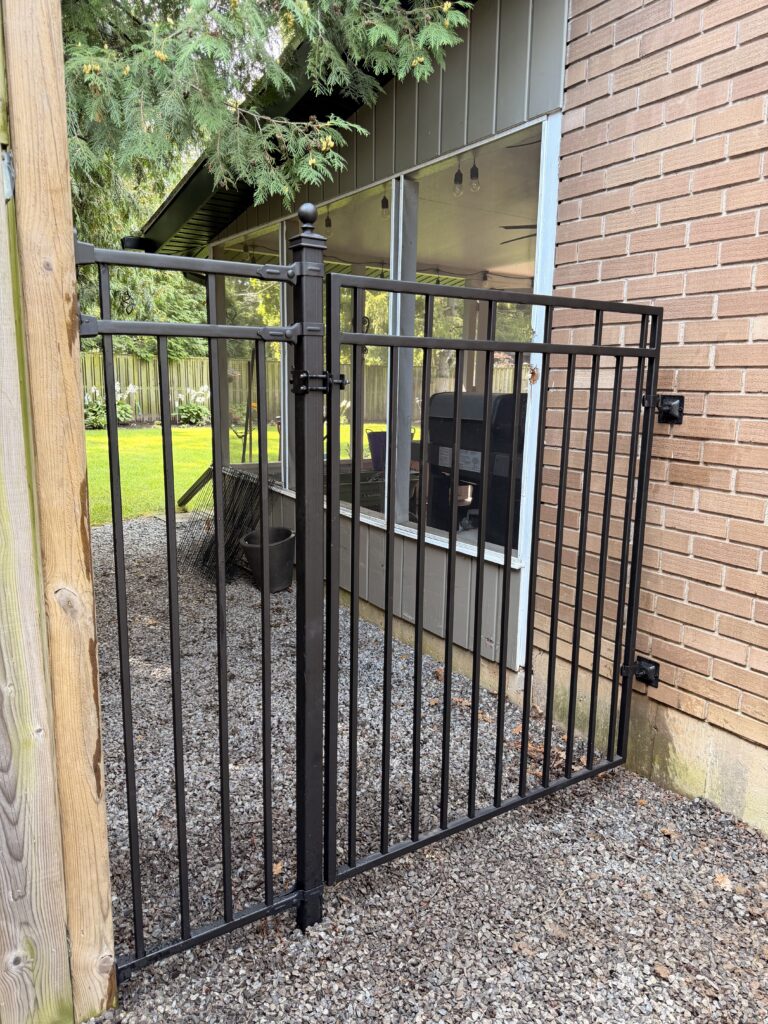 Custom wrought iron gate attached to the home and a fence section.